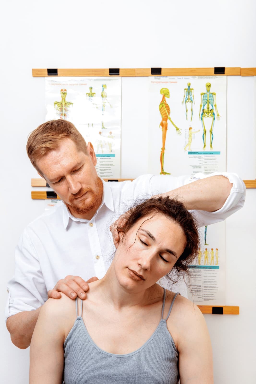 A chiropractor adjusting a patient's neck in a treatment room