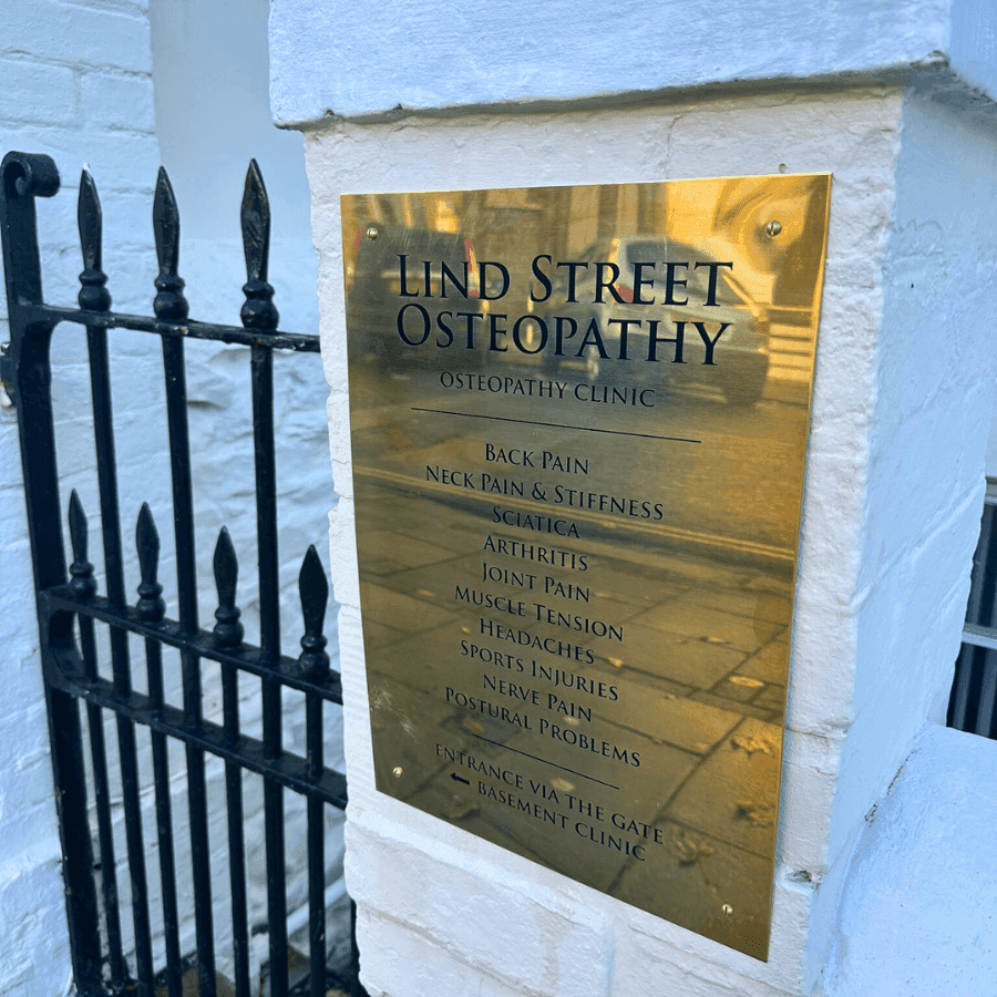 The brass Lind Street Osteopathy clinic sign in Ryde, listing back pain, neck pain, sciatica, arthritis and other conditions treated